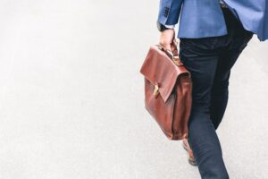person-walking-holding-leather-bag
